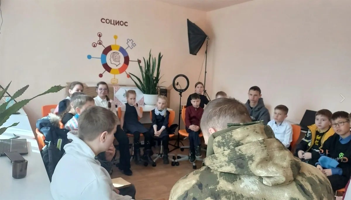 School children are given a military conversation by a warrior from Russia's armed force.